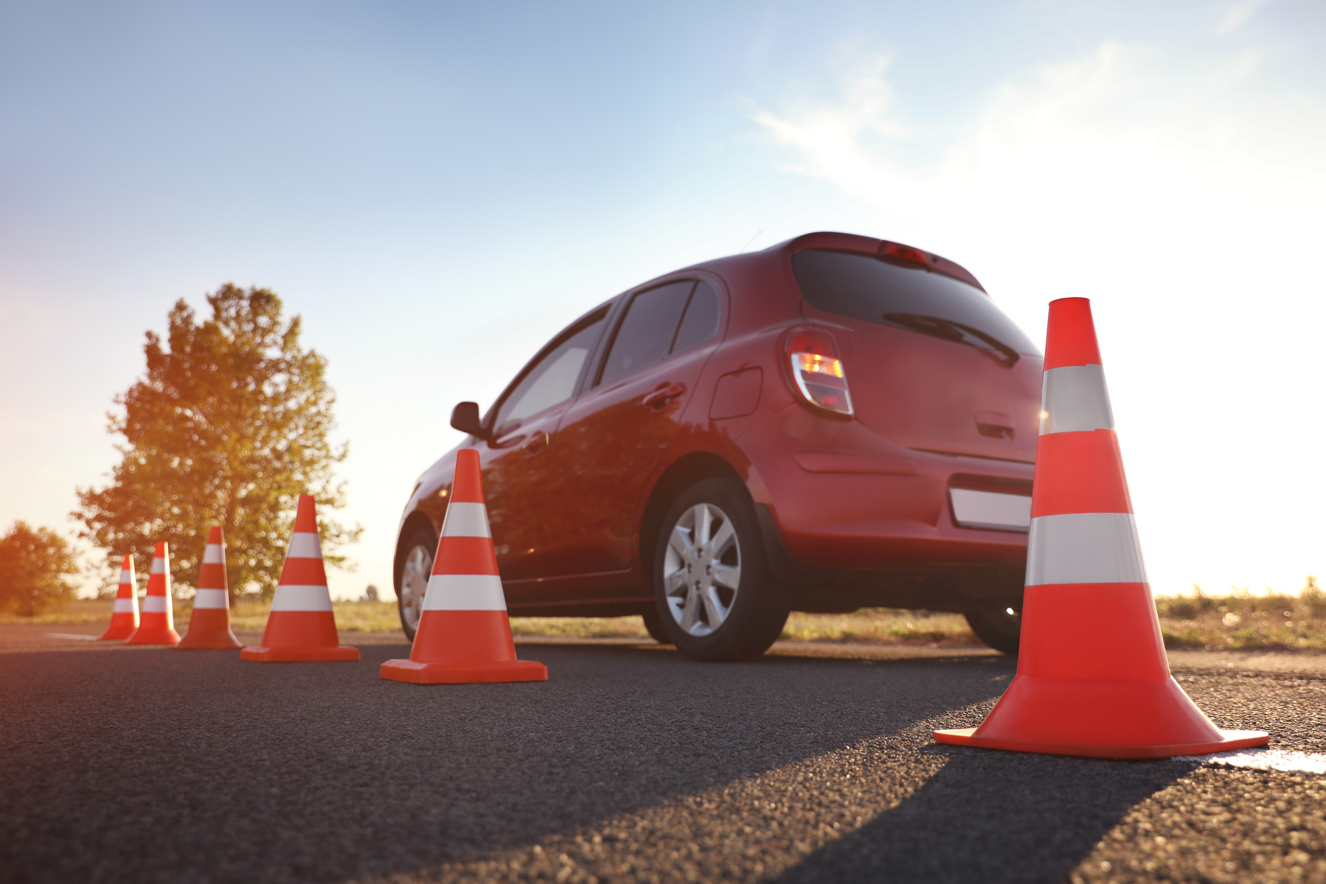 Traffic Cones near Red Car Outdoors. Driving School Exam